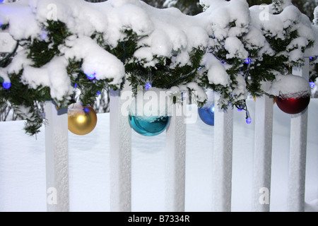 Eine Veranda mit Weihnachtsbeleuchtung Dekorationen und Ornamente mit Schnee bedeckt Stockfoto