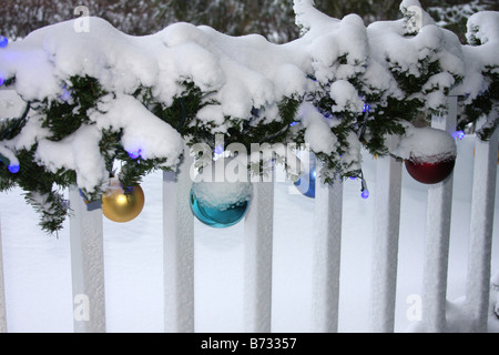 Eine Veranda mit Weihnachtsbeleuchtung Dekorationen und Ornamente mit Schnee bedeckt Stockfoto
