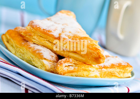 Apple-Umsätze-Gebäck mit Kaffeetassen im Hintergrund Stockfoto