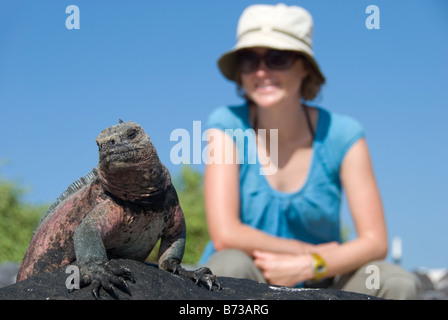 Eine Frau posiert mit einem Leguan auf den Galapagos Inseln Stockfoto