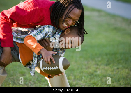 Afroamerikanischen Vater und Sohn spielt Fußball im park Stockfoto