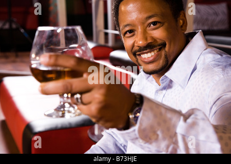 Porträt des afroamerikanischen Jüngling Schnaps Glas im Nachtclub Stockfoto