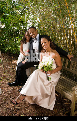 Happy African American Braut und Bräutigam inmitten der freien Natur mit Blumenmädchen Stockfoto