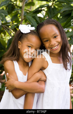 Zwei niedliche afroamerikanische Schwestern in weiß Kleider im Freien stehen Stockfoto