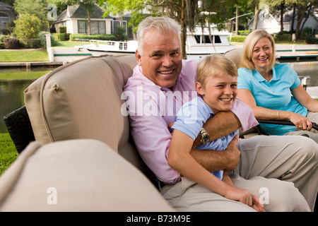 Familie sitzen im Garten mit Blick auf See Stockfoto