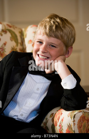 Porträt eines jungen tragen Smoking lächelnd auf Stuhl sitzend Stockfoto