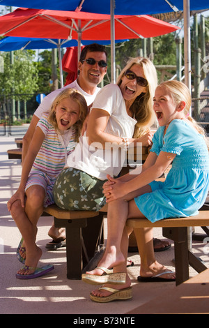 Familie sitzt am Picknicktisch im Wasser Park schreien Stockfoto