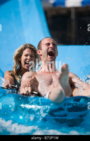 Paar Wasser Rutschen rutschen zusammen auf Innertube im Wasserpark Stockfoto