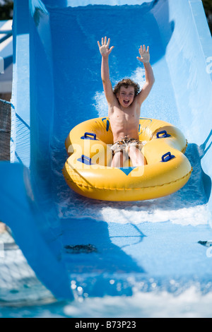 Kleiner Junge Rutschen Wasserrutsche auf Innertube im Wasserpark Stockfoto