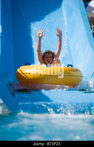 Kleiner Junge Rutschen Wasserrutsche auf Innertube im Wasserpark Stockfoto