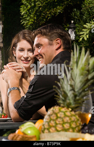 Romantisch zu zweit Mittagessen im Garten, Hand in Hand Stockfoto