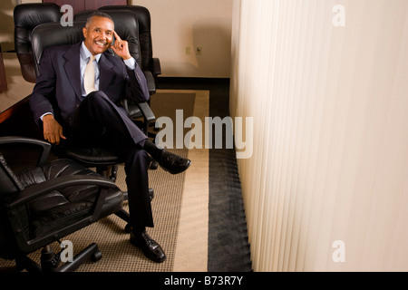 Zuversichtlich, afrikanisch-amerikanischer Geschäftsmann sitzt im Sitzungssaal Stockfoto
