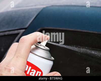 MÄNNLICHE SPRITZEN ENTEISER AUF EIS AM HINTEREN WINDSCHUTZSCHEIBE AUTO HAPPISBURGH NORFOLK EAST ANGLIA ENGLAND UK Stockfoto