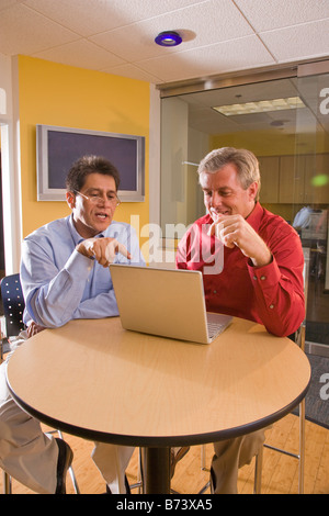 Zwei multi-ethnischen mittleren Alters Geschäftsleute mit Laptop im Büro Stockfoto