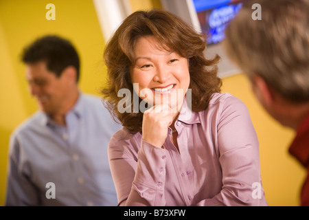 Mittleren Alters asiatische Geschäftsfrau im Gespräch mit männlichen Kollegen Stockfoto