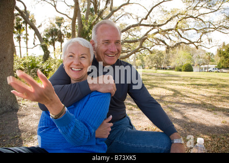 Älteres Paar auf Picknick-Tisch im Garten sitzend, wegschauen Stockfoto