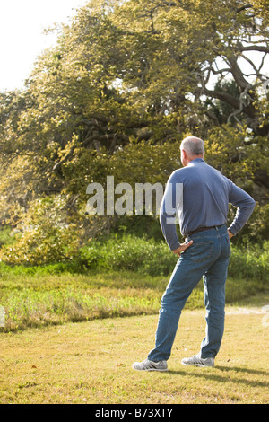 Rückansicht des senior Mann auf dem Rasen im park Stockfoto