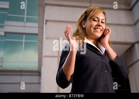 Geschäftsfrau halten Handys vor Bürogebäude Stockfoto
