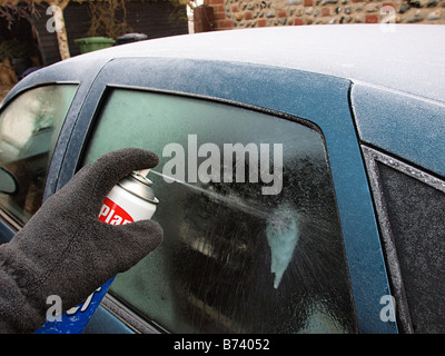 MÄNNLICHE SPRITZEN ENTEISER AUF EIS AM HINTEREN WINDSCHUTZSCHEIBE AUTO HAPPISBURGH NORFOLK EAST ANGLIA ENGLAND UK Stockfoto