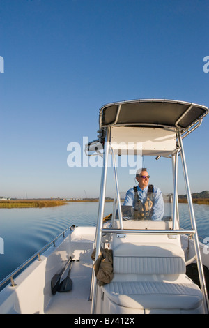 Glückliche Mann mittleren Alters fahren Fischerboot am Fluss Stockfoto