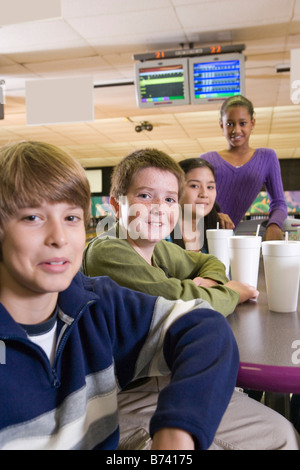Multi-ethnischen Kinder an Tisch in eine Bowlingbahn Stockfoto