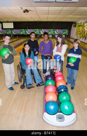 Multi-ethnischen Tweens in eine Bowlingbahn mit Mädchen im Rollstuhl Stockfoto