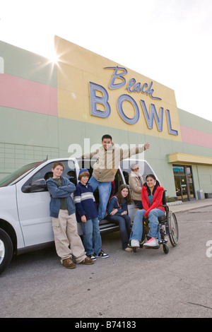 Multi-ethnischen Freundschaften mit Mädchen im Rollstuhl in eine Bowlingbahn Parkplatz Stockfoto