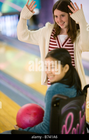 Kinder in eine Bowlingbahn mit Mädchen im Rollstuhl Stockfoto