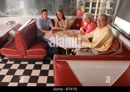 Junges Paar mit Eltern sitzen in den Stand des altmodischen diner Stockfoto