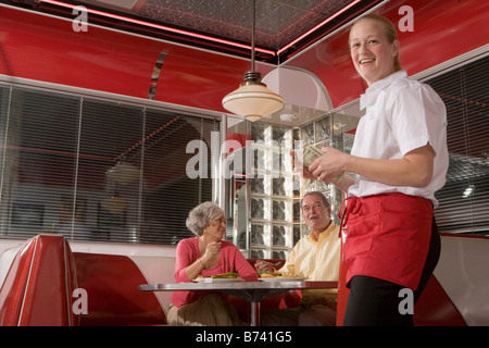 Kellnerin im Restaurant Geld mit paar Restaurants und Bars im Hintergrund halten Stockfoto