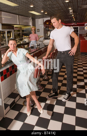 Junge Frau sitzt am Schalter im Diner ignorieren Freund, Stil der 1950er Stockfoto