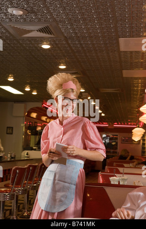 Junge Kellnerin Auftragsannahme im altmodischen Diner Stil der 1950er Stockfoto