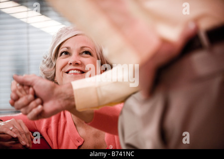 Frau mittleren Alters blickte lächelnd an Mann Stockfoto