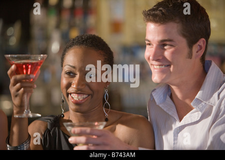 Junges interracial paar Anhebung Getränke sitzen im Restaurantbar Stockfoto
