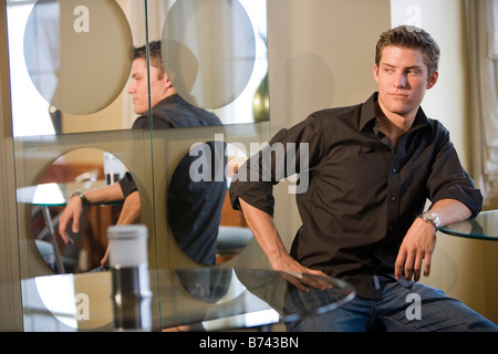 Junger Mann sitzt an einem Tisch in einem restaurant Stockfoto