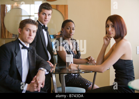 Zwei Paare tragen formelle Kleidung im Restaurantlounge Stockfoto