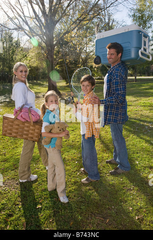 Junge glückliche Familie mit Picknick-Korb und Kühler im park Stockfoto