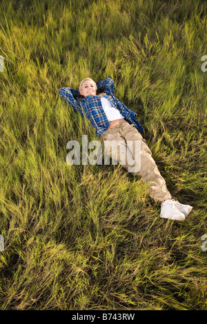 Junge Frau liegt auf dem Rasen, erhöhte Ansicht Stockfoto