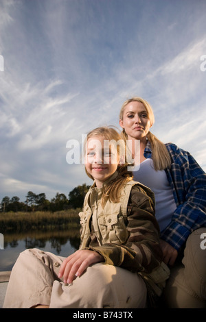 Porträt von Mutter und Tochter sitzen am Campingplatz, Dämmerung Stockfoto