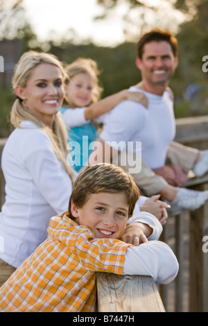 Kleiner Junge lächelnd mit Familie im Hintergrund Stockfoto