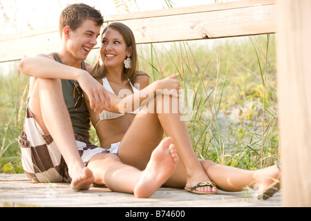 Seitenansicht des junges Paar sitzt am Holzsteg Stockfoto