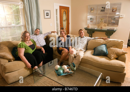 Vier Freunde sitzen auf dem Sofa im Wohnzimmer Stockfoto