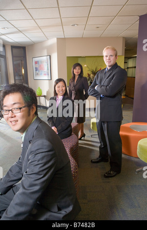 Kaukasische Geschäftsmann warten in der Lobby mit drei asiatischen Führungskräften Stockfoto