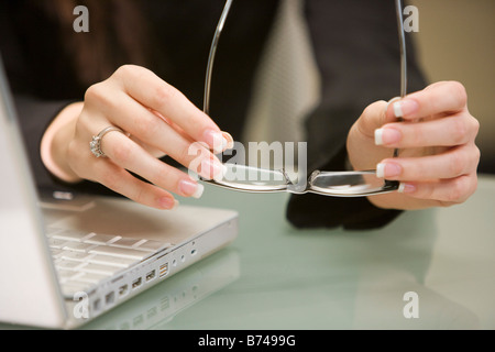 Nahaufnahme von weiblichen Händen mit Brillen von laptop Stockfoto