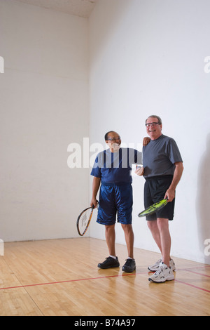 Multi-ethnischen senior Männer lachten und spielten Racketball am Hallenplatz Stockfoto