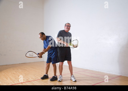 Multi-ethnischen senior Männer spielen Racketball am Hallenplatz Stockfoto