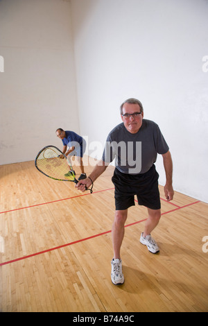 Multi-ethnischen senior Männer spielen Racketball am Hallenplatz Stockfoto