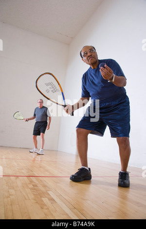 Multi-ethnischen senior Männer spielen Racketball am Hallenplatz Stockfoto