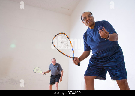 Multi-ethnischen senior Männer spielen Racketball am Hallenplatz Stockfoto