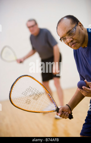 Multi-ethnischen senior Männer spielen Racketball am Hallenplatz Stockfoto